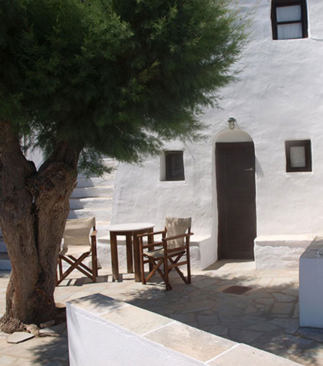 Πλακόστρωτη αυλή με φυσική σκιά από το αλμυρίκι